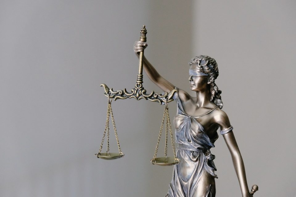 photo by tingey injury law firm woman in dress holding sword figurine
